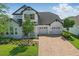 Two-story home with stone accents, a three-car garage, and professionally landscaped front yard at 8378 Randal Park Blvd, Orlando, FL 32832