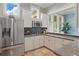 Kitchenette with stainless steel refrigerator, white cabinets, and granite countertops at 8378 Randal Park Blvd, Orlando, FL 32832