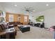 Spacious living room is complete with a large leather couch, ottoman, and a ceiling fan at 8378 Randal Park Blvd, Orlando, FL 32832
