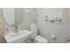 Neutral powder room featuring a white pedestal sink and toilet with a window at 8378 Randal Park Blvd, Orlando, FL 32832