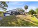 Expansive backyard featuring a covered patio, wooden deck, lush lawn, and scenic waterfront at 106 Edgewater Dr, St Cloud, FL 34769