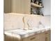 Wet bar featuring white marble countertop, wood cabinets and shelving with bottles and decorative figurines at 106 Edgewater Dr, St Cloud, FL 34769