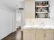 Wet bar featuring white marble countertop, wood cabinets and shelving with bottles and decorative figurines at 106 Edgewater Dr, St Cloud, FL 34769