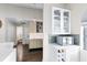 Wet bar featuring white marble countertop, wood cabinets and shelving with bottles and decorative figurines at 106 Edgewater Dr, St Cloud, FL 34769