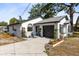 White home featuring a garage and tastefully landscaped front yard with decorative flowers and plants at 106 Edgewater Dr, St Cloud, FL 34769