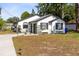 Charming white home with a well-maintained lawn, complemented by decorative plants and a welcoming entryway at 106 Edgewater Dr, St Cloud, FL 34769
