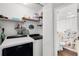 Convenient laundry room with washer, dryer, shelving, and adjacent bathroom at 106 Edgewater Dr, St Cloud, FL 34769