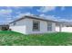 Exterior view of a house with a backyard featuring manicured lawn and blue skies at 109 Lily Ln, Poinciana, FL 34759