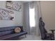 Bedroom featuring white tile flooring, a black futon, and agate artwork at 109 Lily Ln, Poinciana, FL 34759
