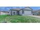 Inviting single-story home with manicured front lawn and a two-car garage with a simple design at 109 Lily Ln, Poinciana, FL 34759