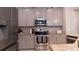 Modern kitchen featuring gray cabinets, stainless steel appliances, and granite countertops with a stylish backsplash at 109 Lily Ln, Poinciana, FL 34759