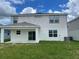 Back of home with covered patio and grassy yard at 1148 Sugarwood St, Davenport, FL 33837