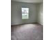 Comfortable bedroom with carpeted floors and a view of the outdoors at 1148 Sugarwood St, Davenport, FL 33837