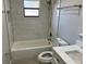 Bathroom with white tub, marble tile surround and modern fixtures with a window for natural light at 1256 S Bumby Ave, Orlando, FL 32806