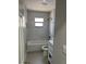 Bathroom with white tub, marble tile surround and modern fixtures with a window for natural light at 1256 S Bumby Ave, Orlando, FL 32806