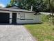 Cozy single-story home featuring a dark garage door and a meticulously paved driveway at 1256 S Bumby Ave, Orlando, FL 32806