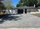 Well-maintained single-story home featuring a dark garage door, new white perimeter fence, and paved driveway at 1256 S Bumby Ave, Orlando, FL 32806