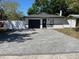 Well-maintained single-story home featuring a dark garage door, new white perimeter fence, and paved driveway at 1256 S Bumby Ave, Orlando, FL 32806