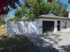 Well-maintained single-story home featuring a dark garage door, new white perimeter fence, and paved driveway at 1256 S Bumby Ave, Orlando, FL 32806
