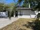 Well-maintained single-story home featuring a dark garage door, new white perimeter fence, and paved driveway at 1256 S Bumby Ave, Orlando, FL 32806