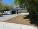 Well-maintained single-story home featuring a dark garage door, new white perimeter fence, and paved driveway at 1256 S Bumby Ave, Orlando, FL 32806