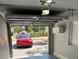 View of the attached garage featuring an automatic door and a red car in the driveway at 1256 S Bumby Ave, Orlando, FL 32806