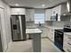 Spacious kitchen with stainless steel appliances, a kitchen island, and bright white cabinets at 1256 S Bumby Ave, Orlando, FL 32806