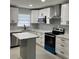A modern kitchen featuring white cabinets, stainless steel appliances, and a kitchen island at 1256 S Bumby Ave, Orlando, FL 32806