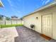 Backyard paver patio featuring a white door, outdoor lighting, and a grill with a view of adjacent houses at 1373 Williams Rd, Winter Garden, FL 34787