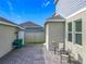 Backyard paver patio, exterior view of house, privacy fence, and green space with grill, chairs, and side door at 1373 Williams Rd, Winter Garden, FL 34787