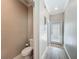 A neutral colored half bathroom has a commode to the left and a door leading to the outside in this well lit space at 1373 Williams Rd, Winter Garden, FL 34787