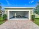 Open garage with epoxy floors, outdoor lighting, and a paver driveway leading to the street at 1373 Williams Rd, Winter Garden, FL 34787