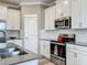 Bright kitchen with white cabinets, stainless steel appliances, subway tile backsplash and a gray countertop with a double sink at 1373 Williams Rd, Winter Garden, FL 34787