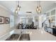 Open-concept kitchen with quartz countertops, stainless steel sink and modern pendant lighting overlooking dining and living areas at 1373 Williams Rd, Winter Garden, FL 34787