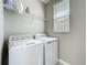 Bright laundry room featuring a white washer and dryer along with wire shelving for storage at 1373 Williams Rd, Winter Garden, FL 34787