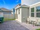 Paver patio outside the home, featuring chairs and a small table; a grill can be seen in the yard at 1373 Williams Rd, Winter Garden, FL 34787