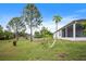 Spacious backyard featuring mature trees, lush lawn, and a screened-in lanai for year-round enjoyment at 1688 Tamarind Rd, Davenport, FL 33896