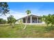 The backyard with the screened-in lanai, well-maintained lawn, and lush greenery creates a serene retreat at 1688 Tamarind Rd, Davenport, FL 33896