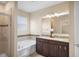 Primary bathroom featuring double vanity with granite countertop, soaking tub, and glass enclosed shower at 1688 Tamarind Rd, Davenport, FL 33896