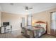 Bright bedroom with a ceiling fan, wood-look floors, and a cozy quilt bedspread at 1688 Tamarind Rd, Davenport, FL 33896