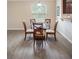 Bright breakfast nook features a round glass table and seating for four under a modern light fixture at 1688 Tamarind Rd, Davenport, FL 33896