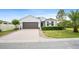Beautiful one-story home with a lush lawn, a front bay window and a large driveway at 1688 Tamarind Rd, Davenport, FL 33896