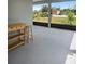 Enclosed lanai with wood serving cart, stool, and views of the neighborhood at 1688 Tamarind Rd, Davenport, FL 33896