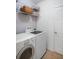 Bright laundry room with washer, dryer, and wire shelving at 1688 Tamarind Rd, Davenport, FL 33896
