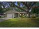 Charming single-story home featuring a mature tree, well-maintained lawn, and attached two-car garage at 17 Juniper Dr, Davenport, FL 33837