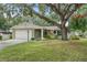 Charming single-story home featuring a mature tree, well-maintained lawn, and attached two-car garage at 17 Juniper Dr, Davenport, FL 33837