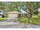 Charming single-story home featuring a mature tree, well-maintained lawn, and attached two-car garage at 17 Juniper Dr, Davenport, FL 33837