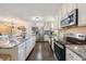 Spacious kitchen offers an island, stainless steel appliances, white cabinetry, and dark hardwood floors at 17 Juniper Dr, Davenport, FL 33837