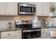 Close up of modern kitchen featuring stainless steel appliances, granite countertops, and white cabinetry at 17 Juniper Dr, Davenport, FL 33837