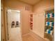 Hallway with a view to the laundry room; also features shelving and bench with towels for post pool use at 2147 Tripoli Ct, Kissimmee, FL 34747